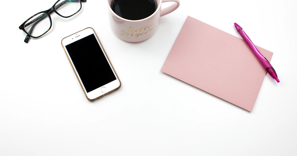 Telefono accanto a tazze di caffè e occhiali, l’attrezzatura essenziale del briefing mattutino